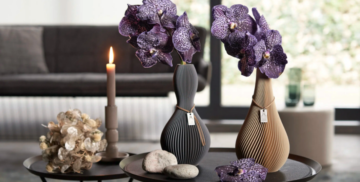 Shape e Twist con orchidee Vanda viola, accompagnati da pietre lisce e lunaria.
