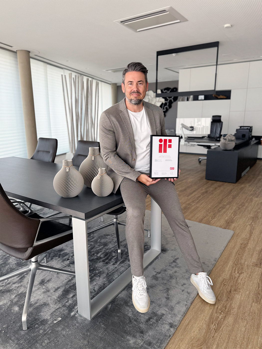 Nicolas Woll in seinem Büro mit der iF Design Award Urkunde